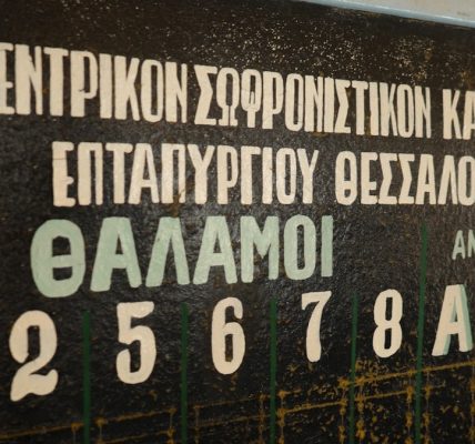 Greek text and numbers are visible on a blackboard.