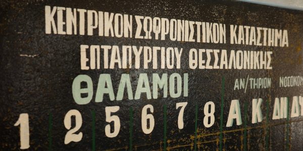 Greek text and numbers are visible on a blackboard.